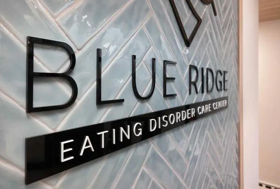 The image shows a sign with the text BLUE RIDGE prominently displayed above a tagline reading Eating Disorder Care Center.