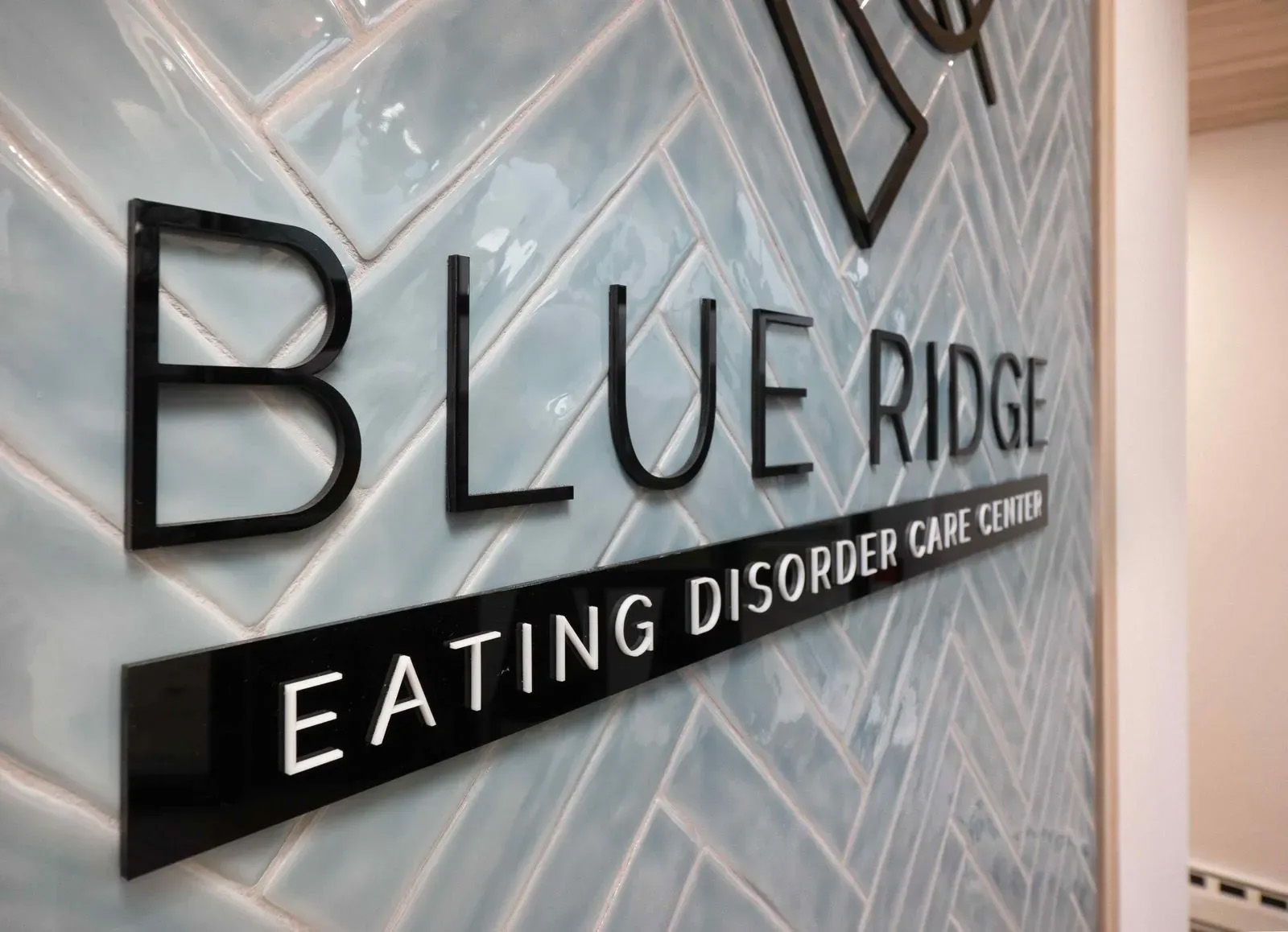 The image shows a sign on a wall with text that reads  BLUE RIDGE  at the top, followed by  Eating Disorder Center,  indicating the name of an organization related to eating disorders.