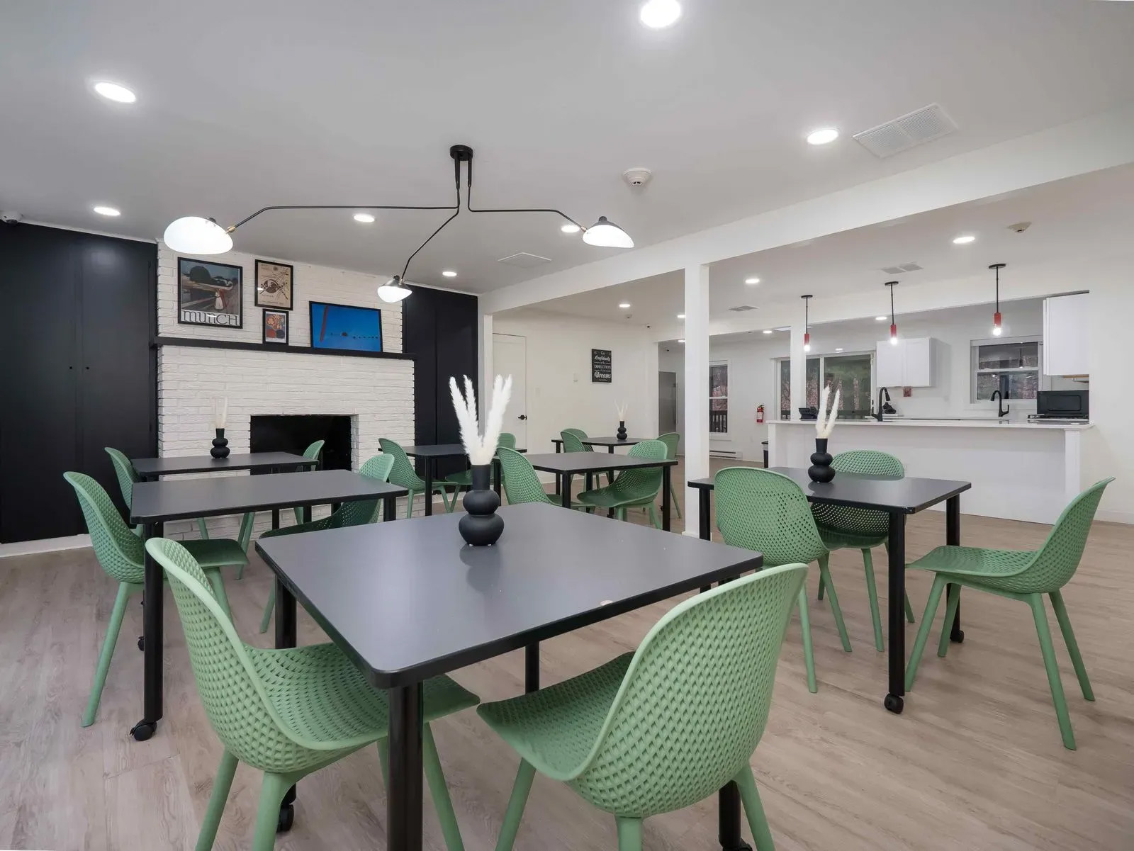 The image shows a modern dining room with a large dining table surrounded by green chairs.